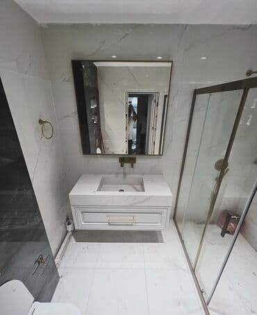 qapi aksesuarlari: Mərmər effektli ağ rəngdə divara quraşdırılan dolablı unitaz. Dolabda — 2