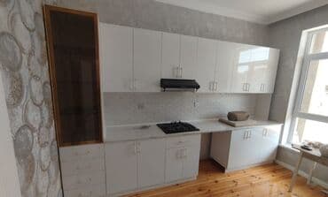 Ağ rəngdə olan mətbəx mebeli dəsti. Qaz plitəsi və aspirator üçün