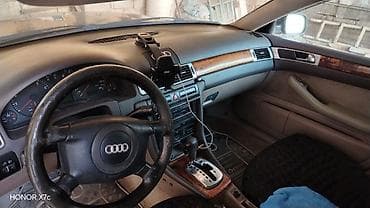 ucuz motolar: Audi A6 sedan təqdim olunur. Avtomobil tünd rəngdədir, 4 qapılı кузов — 3