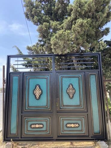 demir qapi bezekleri: Qara rəngdə, bürünc elementlərlə bəzədilmiş metal qapı. Qapının — 2