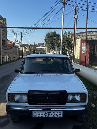 raf masin: VAZ 2107, ağ rəng, sedan kuzov. 4 qapı, 5 yerlik salon. Qara radiator — 3