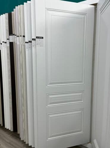 Ağ rəngdə, klassik dizaynlı qapı. Qapının üzərində üç ədəd panel var