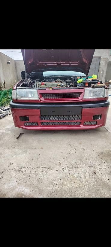 Qırmızı rəngli, torlu dizaynlı avtomobil bamperi. Avtomobilin ön