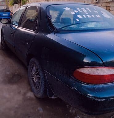 əllə çəkilmiş maşın şəkilləri: Kia Sephia sedan - Kuzov: 4 qapılı sedan, tünd yaşıl rəng - Ön hissə — 5