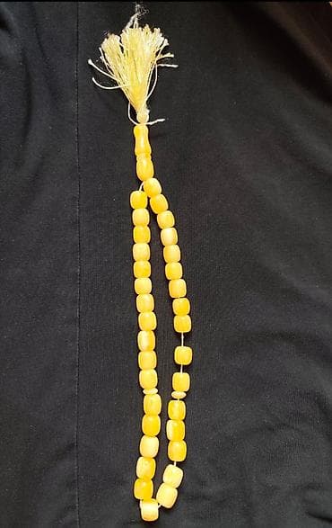 Sarı rəngdə, künc formalı kəhrəba muncuqlar ilə təsbeh. Muncuqlar incə