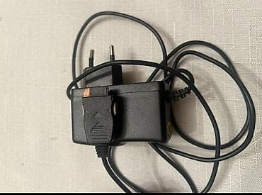 Bu qara rəngli şarj cihazı, bir divar rozetkasına qoşulmaq üçün iki