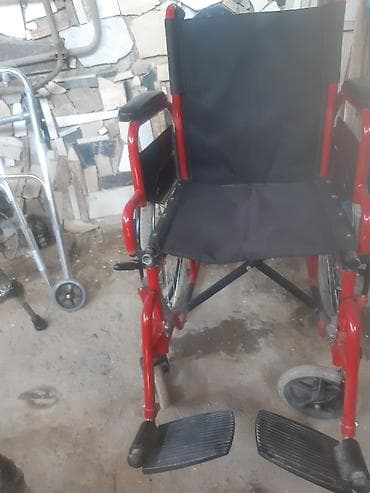 Bu, qırmızı rəngli metal çərçivəli və qara parça oturacaqlı əlil