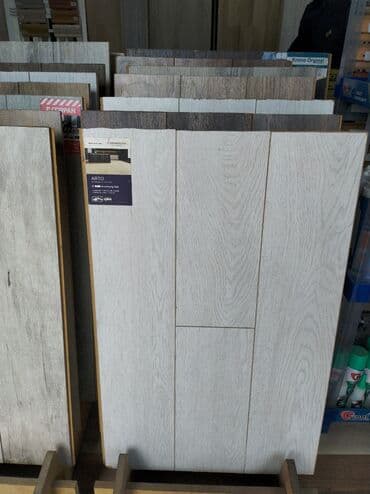 Açıq rəngli, ağac naxışlı laminat döşəmə panelləri. Bu panellər