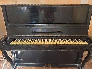 gitara simi: Upright piano – klassik qara korpuslu, dekorativ oyma panellərlə. - — 1