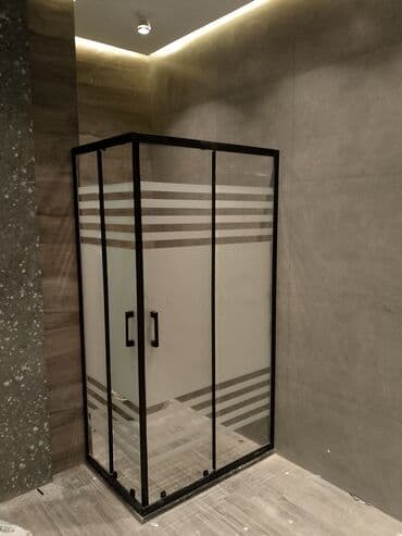 Qara çərçivəli və zolaqlı şüşəsi olan duş kabinəsi. Bu dizayn hamam