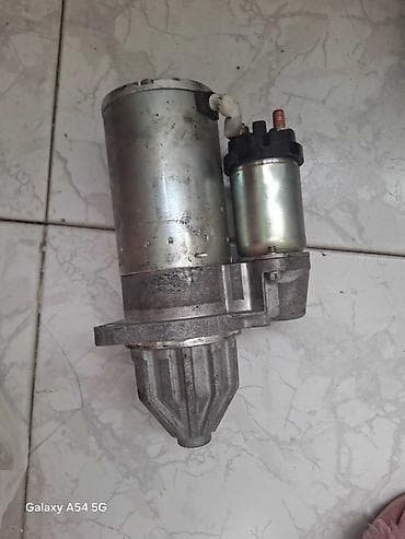 Gümüşü rəngdə, avtomobil üçün nəzərdə tutulmuş starter. Mühərrikin işə