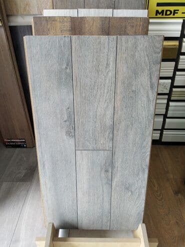 Ağac naxışlı, boz rəngli laminat döşəmə paneli. Ev və ya ofis