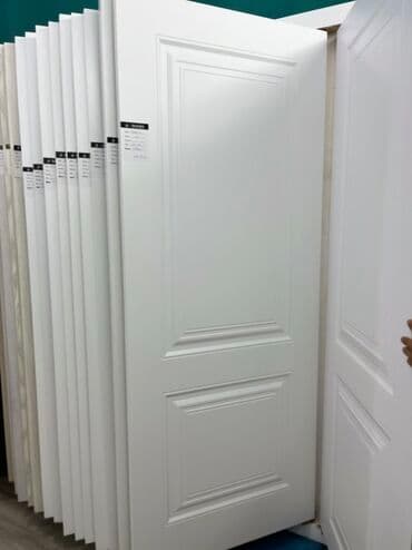 Ağ rəngdə, sadə dizaynlı qapı. Panelləri olan düzbucaqlı forması