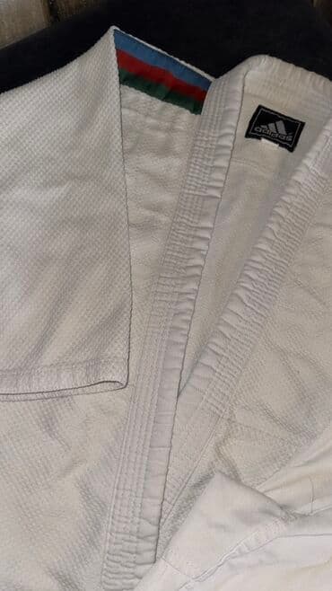 Ağ rəngdə olan Adidas judo kostyumu. Üzərində Azərbaycan bayrağının
