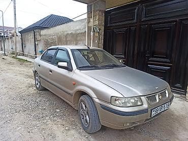 saipa 132 se: Açıq qəhvəyi rəngdə sedan tipli avtomobil. Avtomobilin ön hissəsində — 3