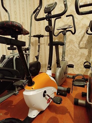 Evdə idman etmək üçün nəzərdə tutulmuş stasionar velosiped. Qızılı və