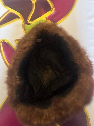 Uniseks qış papağı sıx, qəhvəyi rəngli xəzdən hazırlanıb. Papağın iç