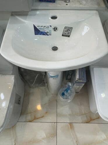 Ayaq üstü quraşdırılan, ağ rəngli keramika lavabo. Oval formaya