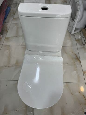 Ağ rəngdə, iki hissədən ibarət unitaz. Kompakt dizaynı ilə hamam