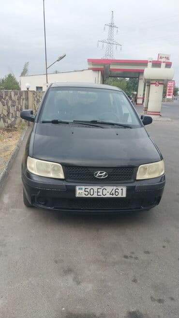 Ön hissəsində Hyundai loqosu və "H" emblemi olan qara rəngli Hyundai