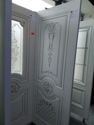 qapi mdf: Ağ rəngli qapı, üzərində klassik naxışlar və dekorativ elementlər var — 1