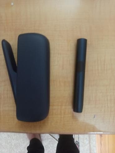 Qara rəngdə elektron tütün qızdırma cihazı və portativ şarj/şaquli — 1