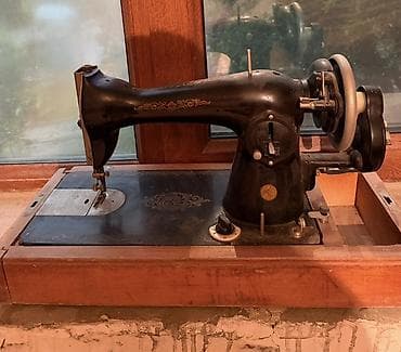 12 volt mator: Tünd rəngli metaldan hazırlanmış köhnə mexaniki tikiş maşını. Maşın — 2