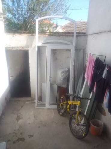 kodlu blok qapilari: Ağ rəngdə, yuxarı hissəsində qövsşəkilli əlavəsi olan plastik qapı. Ev — 2
