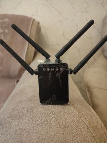 simsiz internet wifi: Qara rəngdə olan, dörd antenalı Wi-Fi gücləndiricisi. Evdə və ya — 4