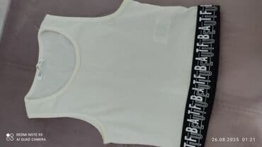 Ağ rəngli qadın qısa topu. Dairəvi yaxalı və qolsuz dizayna malikdir — 1