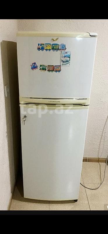 Ağ rəngdə, iki bölməli soyuducu. Yuxarı hissə soyuducu, aşağı hissə