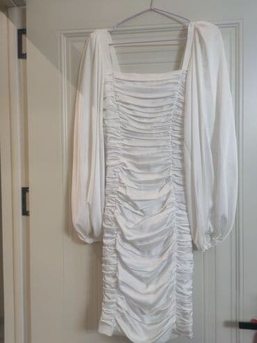 Ağ rəngli, büzməli dizaynlı qadın paltarı. Uzun, şişirdilmiş qolları