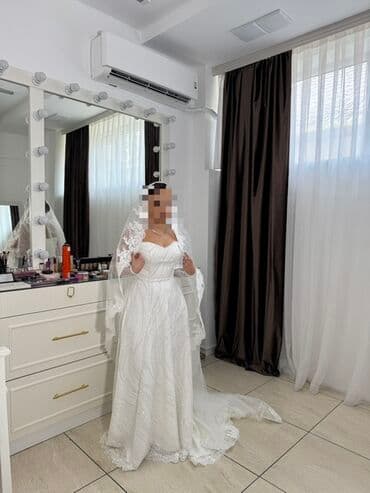 Zərif krujeva detalları və uzun ətəyi olan, ağ rəngli gəlinlik