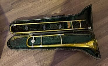 trombon: Nəfəsli alətlər qrupuna aid olan bu trombon parlaq qızılı rəngdədir — 1