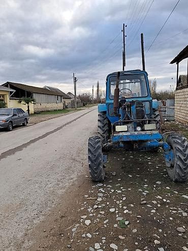 Mavi rəngli təkərli kənd təsərrüfatı traktoru və qoşqu dəsti