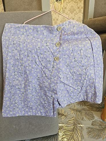 Bənövşəyi rəngdə, xırda çobanyastığı naxışlı qadın ətəyi. Yana doğru