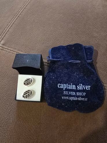 gumuş bilərziklər: Dəyirmi, oval formalı, qara və gümüşü rəngli manjet düymələri. Hər bir — 2