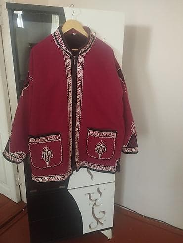 - Qırmızı milli naxışlı üst geyimi: Dizaynı Qarabağ/Qafqaz motivli