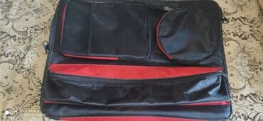Qara və qırmızı rənglərdə olan geyim daşıma çantası. Bir neçə əlavə