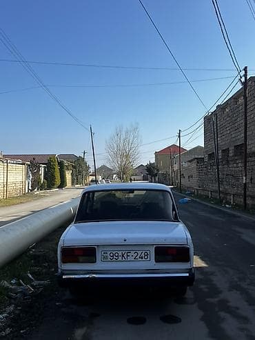raf masin: VAZ 2107, ağ rəng, sedan kuzov. 4 qapı, 5 yerlik salon. Qara radiator — 1