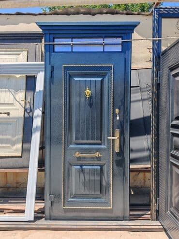 pəncərə qapi: Naxışlı qızılı haşiyəli, qara rəngli metal giriş qapısı. Qapının üst — 1