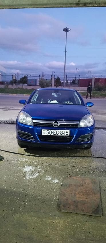 Opel Astra H – mavi rəng, sedan/hetçbek kuzov (ön görünüş). Nömrə