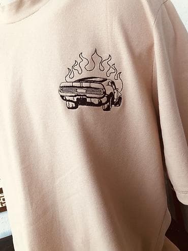 flo memar ecemi: Bej rəngli qısaqoll T‑şört - Minimalist dizayn: sinə hissəsində alov — 2