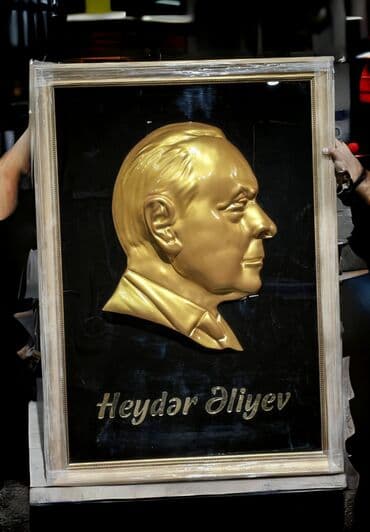 əla şəkillər: Heydər Əliyevin qızılı rəngdə barelyefi olan, qara fonda və çərçivəyə — 1