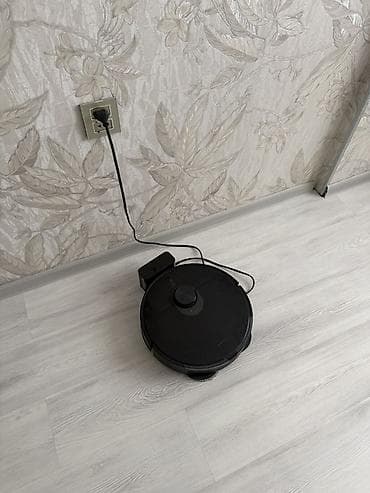 Ağıllı robot tozsoran – yuvarlaq gövdəli, qara rəngli model, şarj