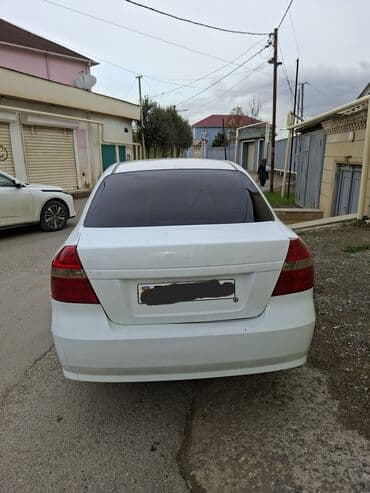 Ağ rəngli 4 qapılı sedan. Xüsusiyyətlər: - Yanacaq növü: benzin -