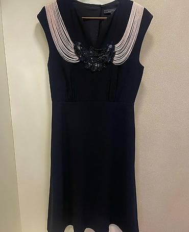 Qadın paltarı – qara rəng, dizüstü uzunluq, qolsuz. Yaxa hissəsində — 1