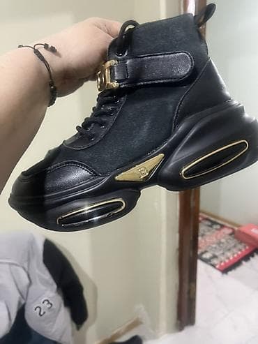 Qara rəngdə, qızılı detallar ilə dizayn olunmuş yüksək sortlu qadın