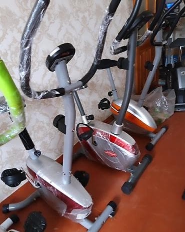 Qırmızı və gümüşü rəngli, qolları olan stasionar velosiped trenajoru