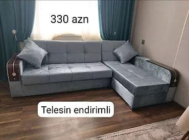 Künc divan – toxuması yumşaq, boz/rəngli parça üzlüklə. L‑şəkilli